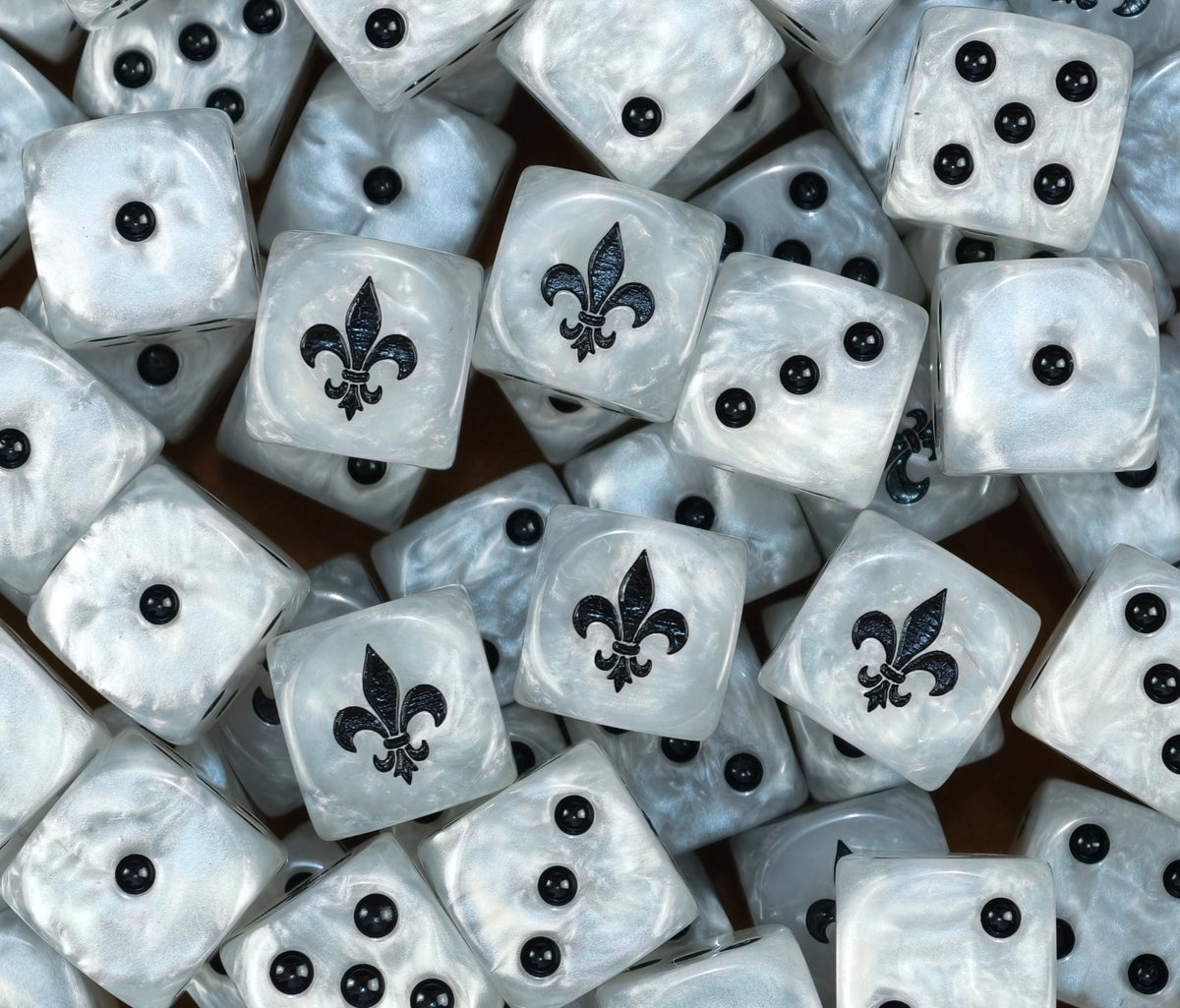 A pile of pearl white Battle Sisters dice with black fleur de lis emblems