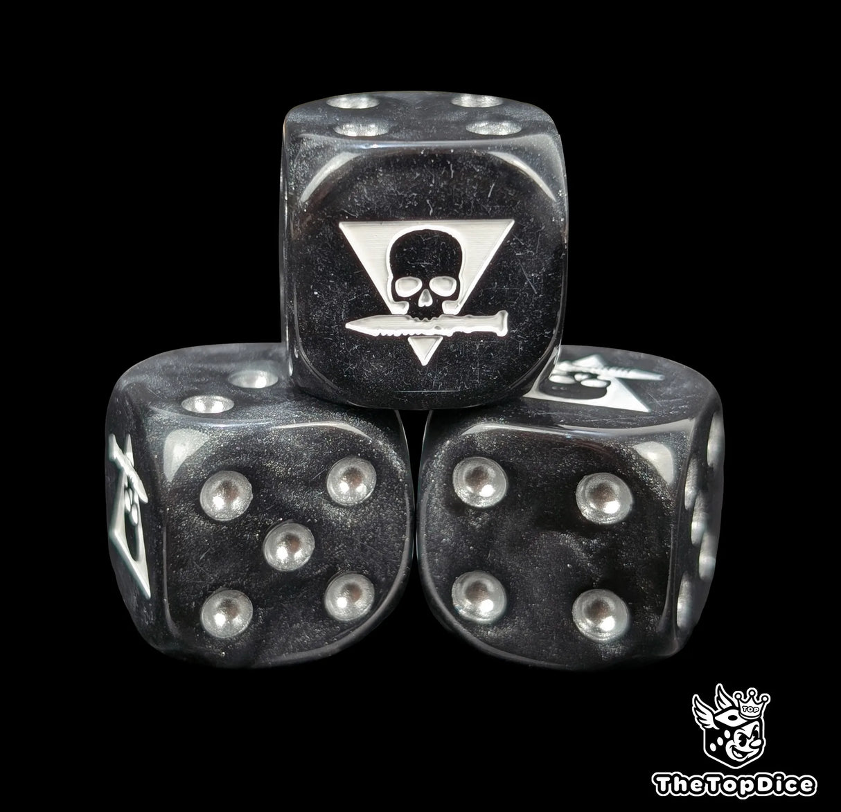 Close up of a black 16mm resin D6 die engraved with a triangle skull biting a white knife