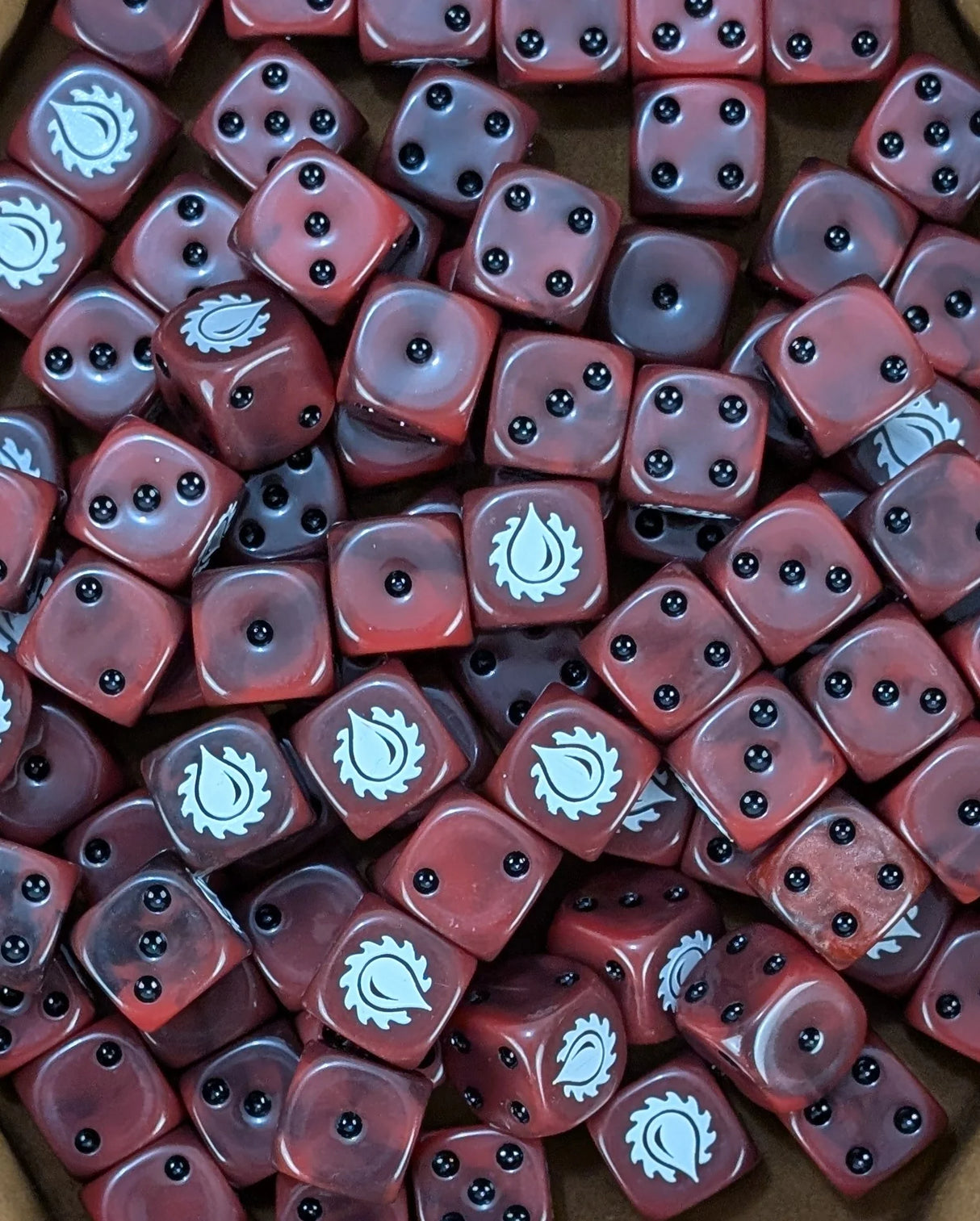 Pile of blood red 16mm D6 dice with white blood drop emblems for a sci-fi rage army