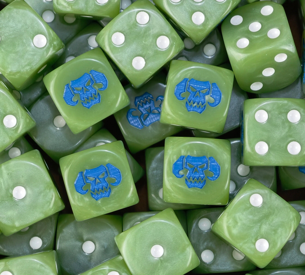 A pile of snot green Ork D6 with white pips and blue horned skulls
