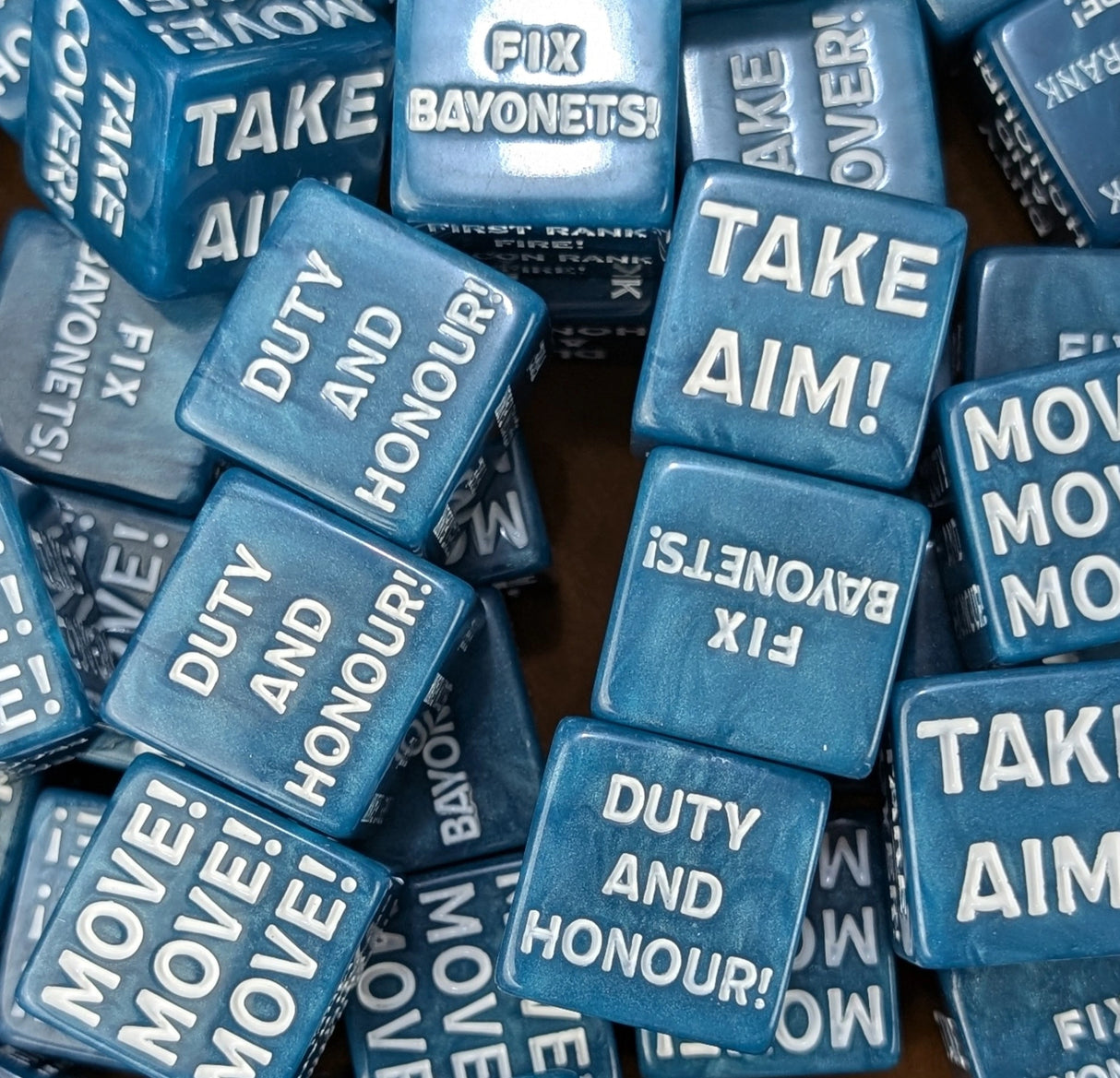 Pile of blue 20mm command tokens beside a sci-fi trench guard army on the table