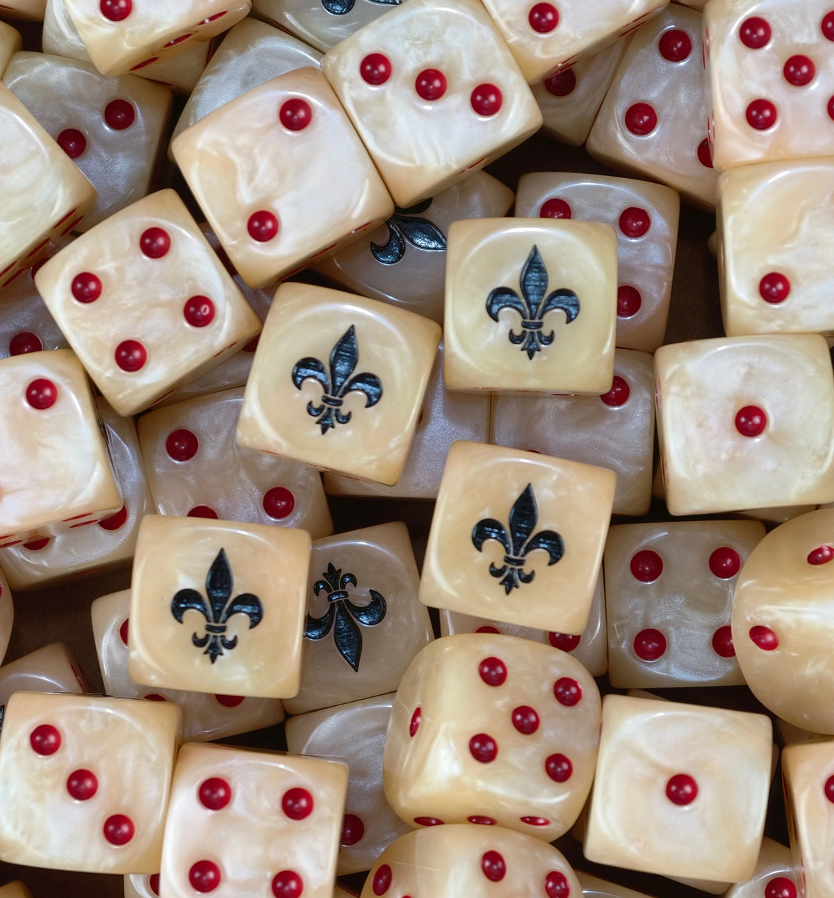 A pile of cream Adepta Sororitas dice with red pips and black fleur de lis