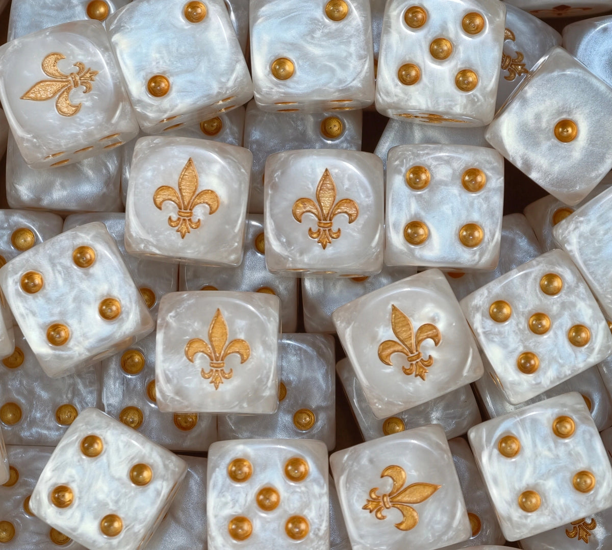 A pile of pearl Adepta Sororitas dice with gold pips and gold fleur de lis