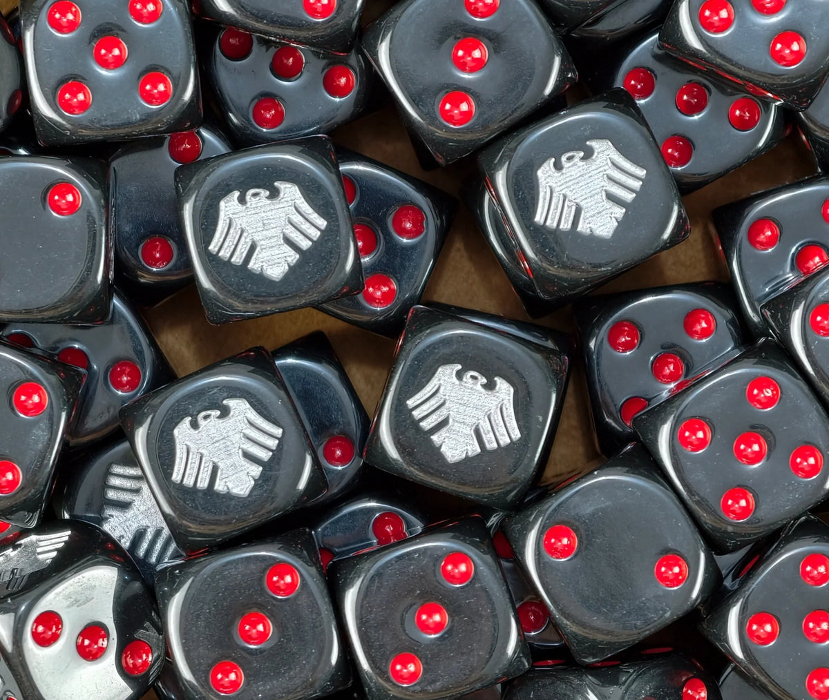 A pile of black Raven Guard dice, silver ravens and red pips repeating