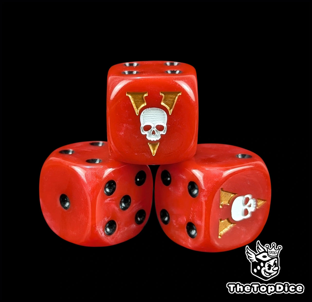 Close up of a red 16mm resin D6 die engraved with a white skull and gold blade and black pips