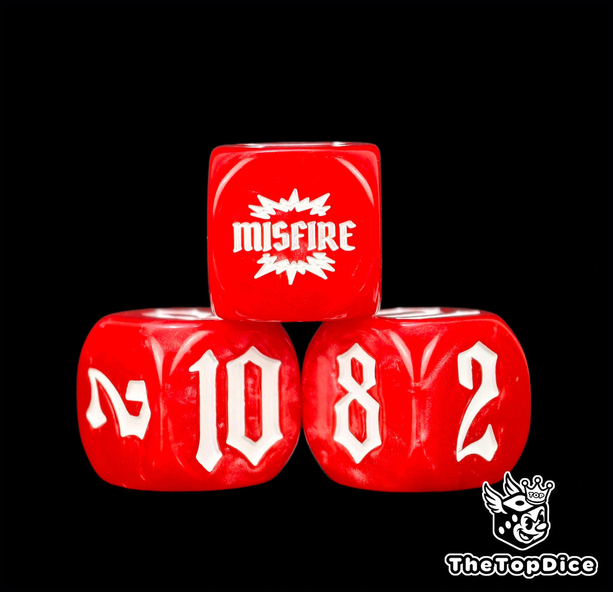 Four marbled red 16mm dice close up, the MISFIRE burst sitting above the 10 and 8