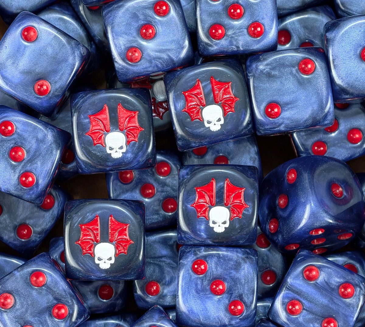 A pile of slate blue Night Lords D6 with red pips and red wings