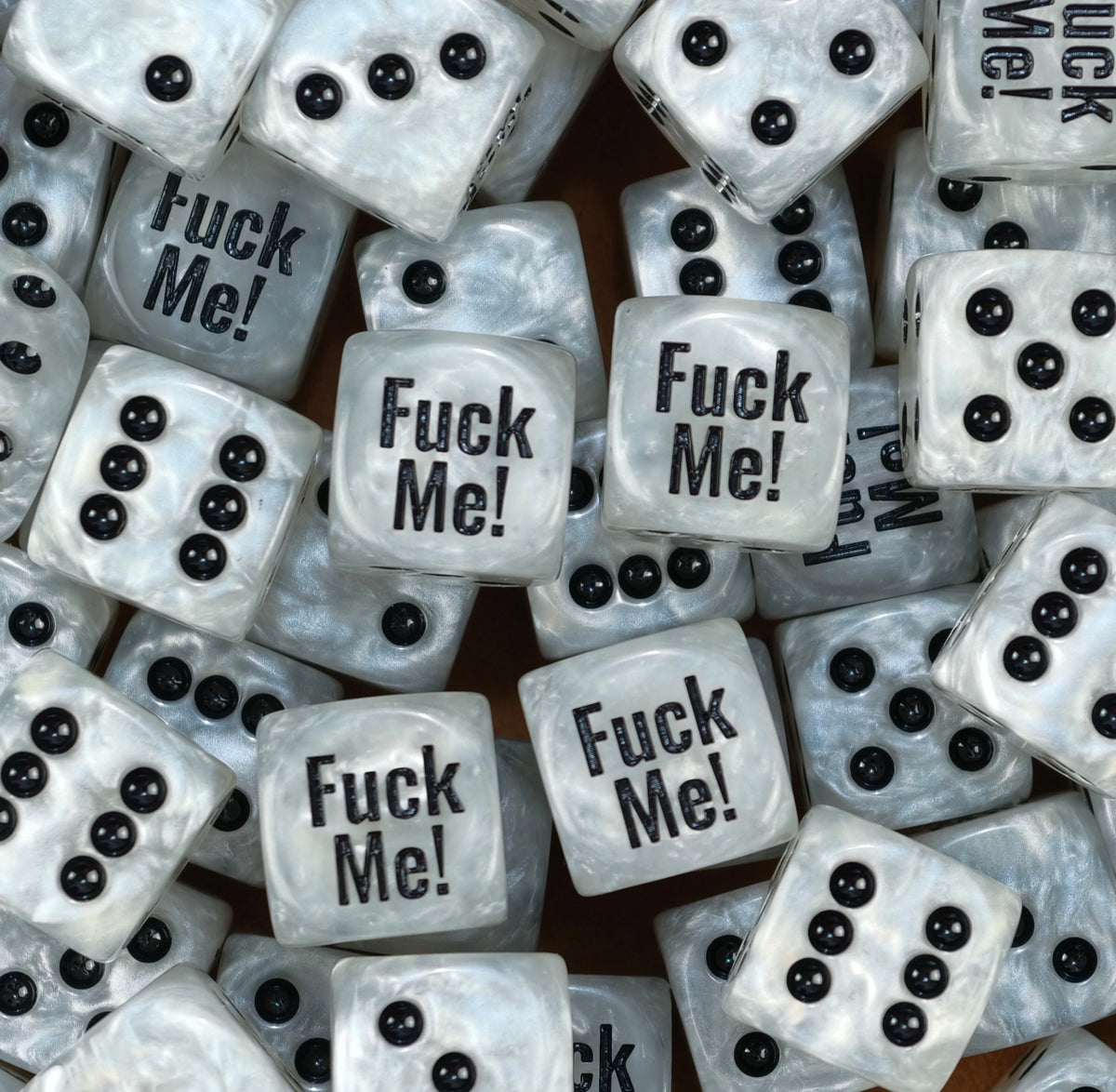 A pile of pearl white Fuck Me meme D6 with black pips and print
