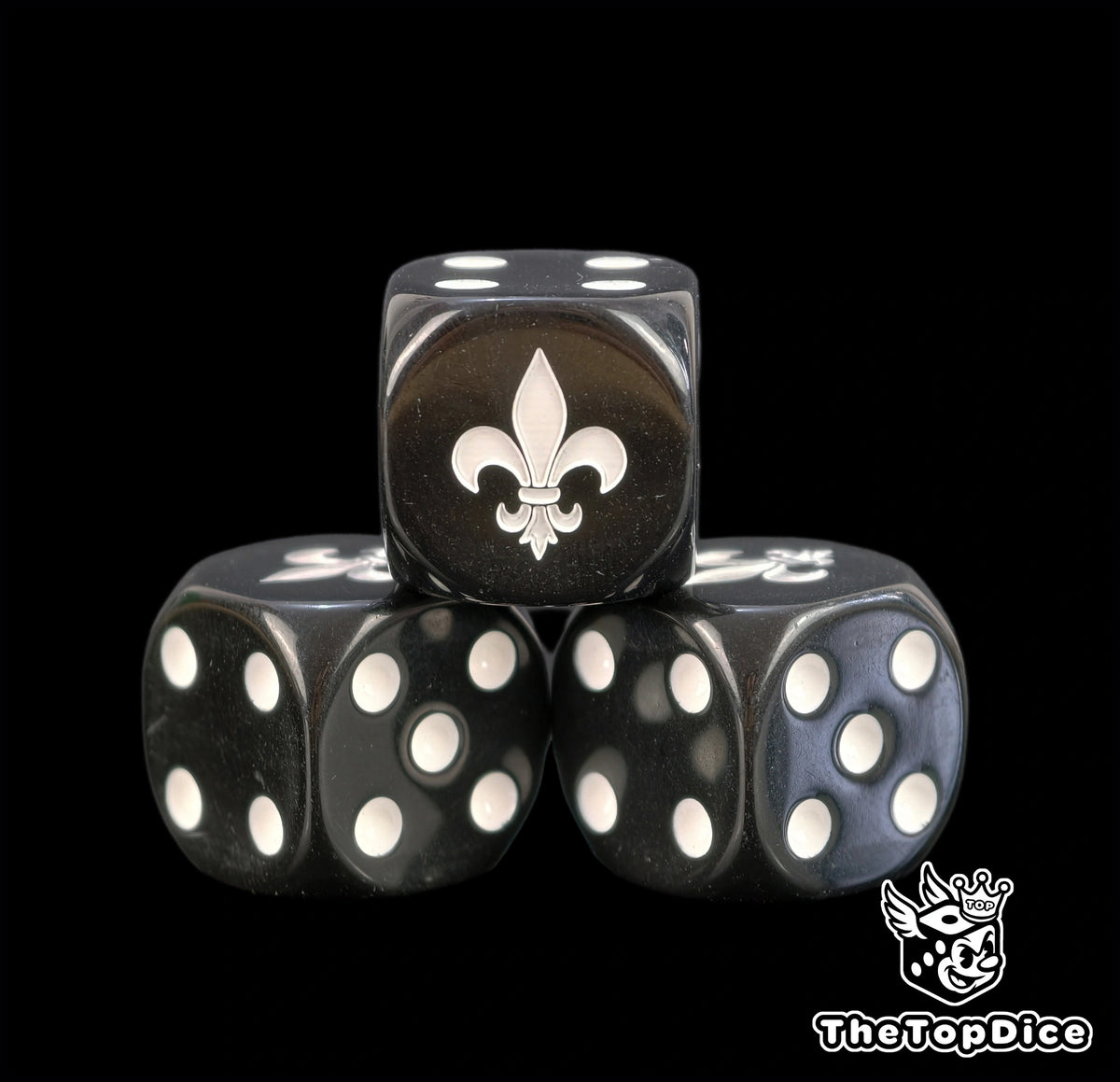 Three black Sororitas dice with cream pips and a white fleur de lis