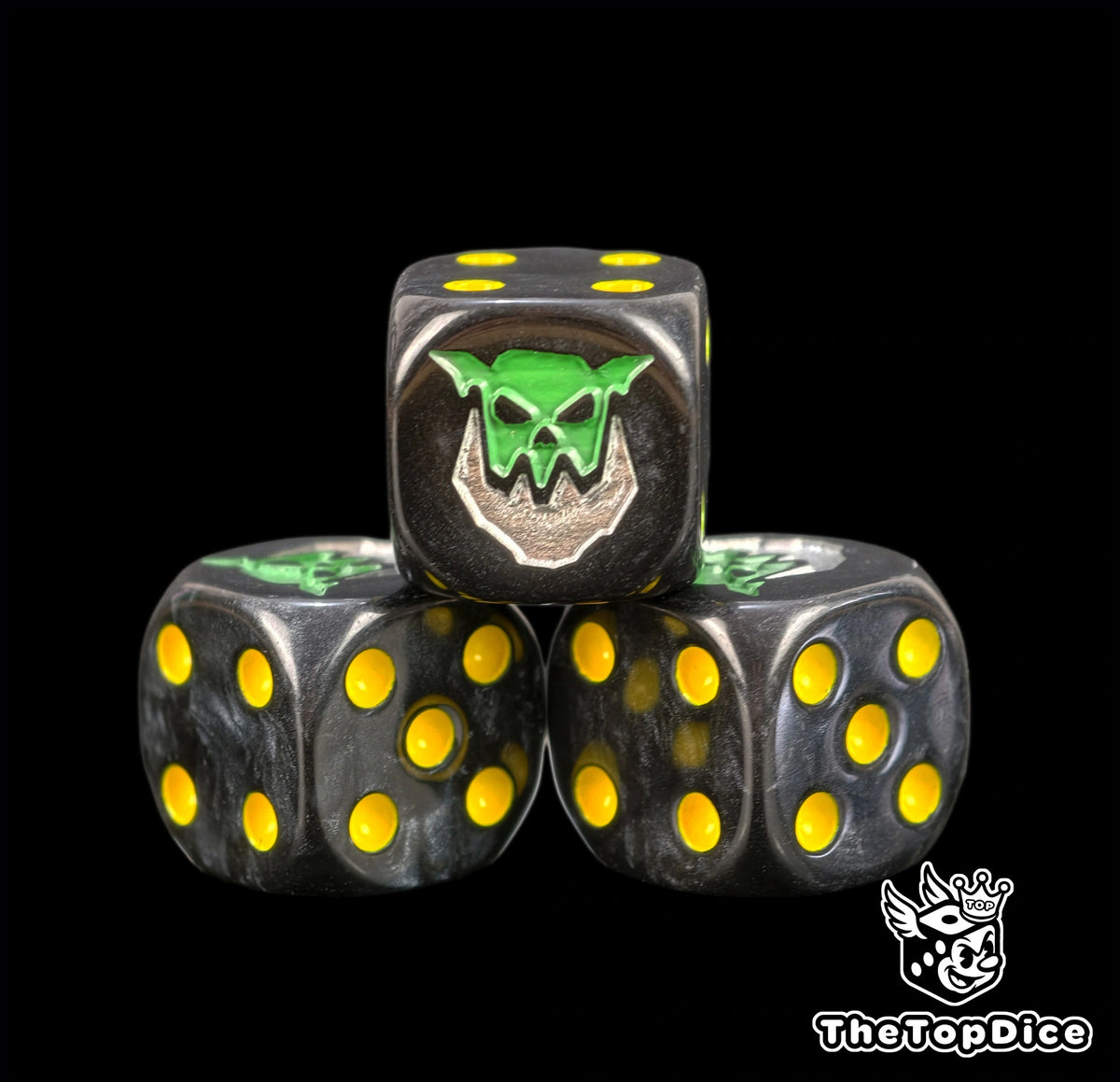 dados inspirados en los orkos iron jawz de warhammer de age of sigmar de base de color negro puntos amarillos y el logo es una cara de orko verde que tiene una mandibula de iron color silver
