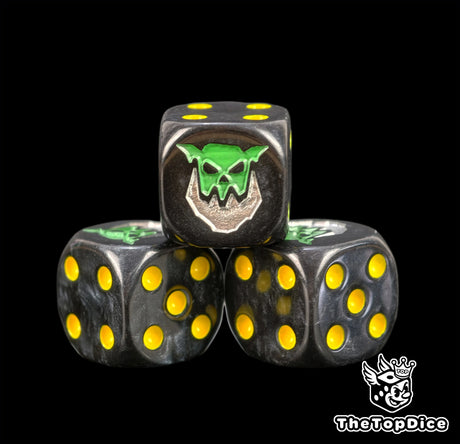 Close up of black Ironjawz dice with yellow pips and a green orruk head fitted with an iron jaw