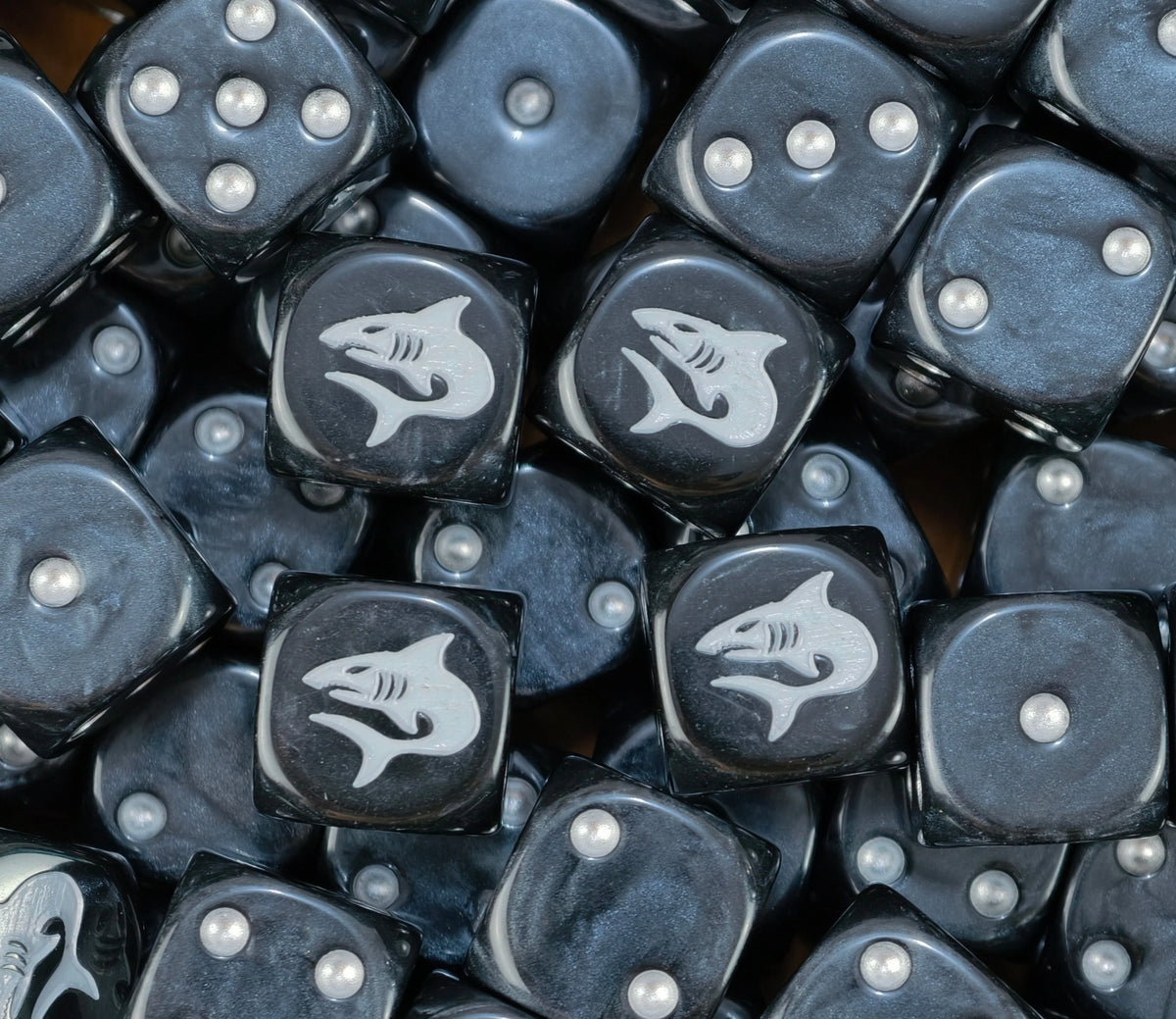 A pile of black Carcharodons dice, white sharks and silver pips repeating