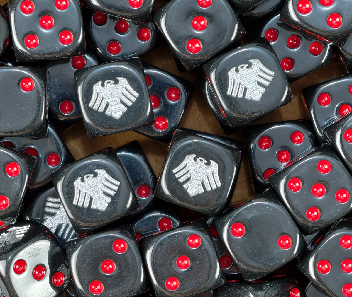 A pile of black Raven Guard dice, silver ravens and red pips repeating