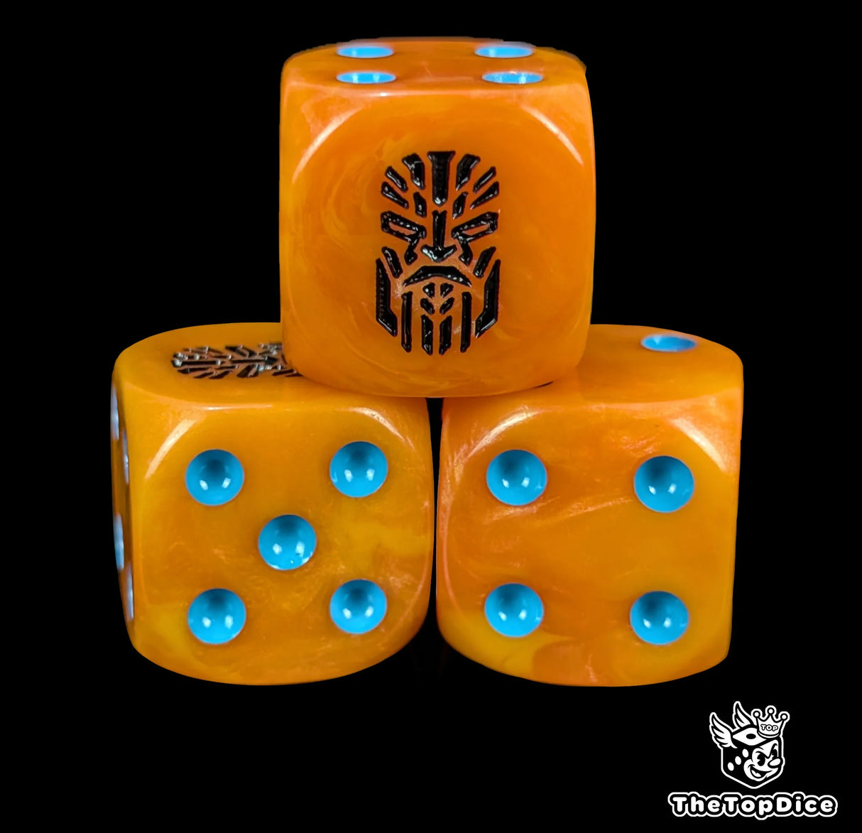 Close up of an orange 16mm resin D6 die engraved with a black rune and a stern face and blue pips