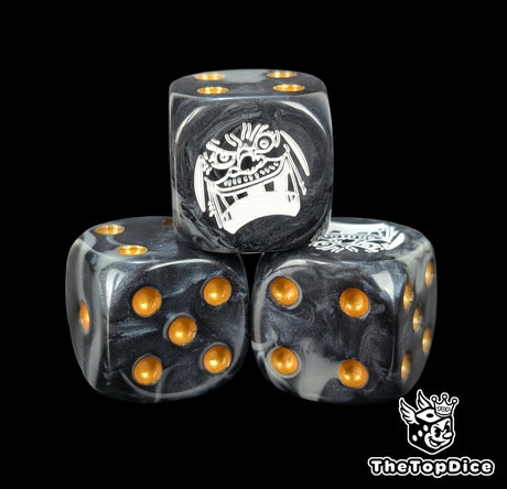 Close up of a black and grey 16mm resin D6 die engraved with a white laughing emblem and gold pips