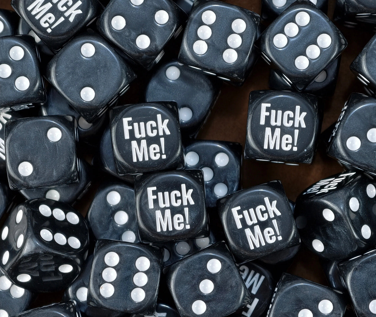 A pile of black Fuck Me meme D6 with bone white pips and print
