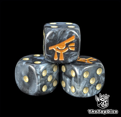 Close up of a black and grey 16mm resin D6 die engraved with a gold eye and beige pips