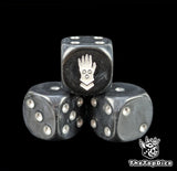 Close up of a black 16mm resin D6 die engraved with a white iron hand and silver pips