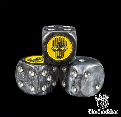 Close up of a black and grey 16mm resin D6 die engraved with a yellow helm silhouette and silver pips