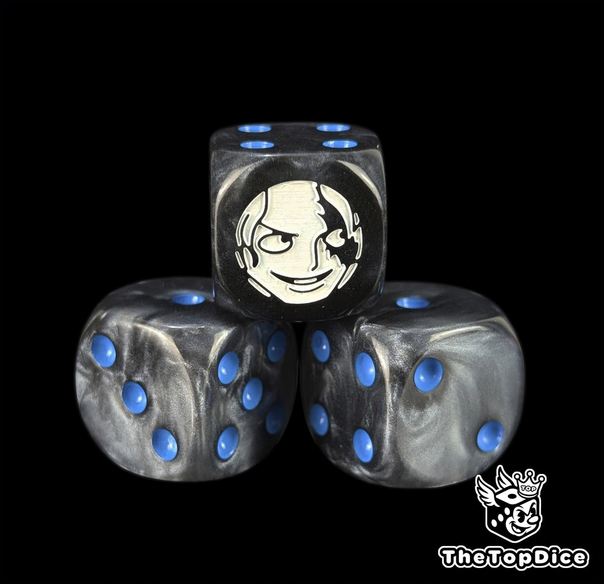 Close up of a black 16mm resin D6 die engraved with a white fighter emblem and blue pips