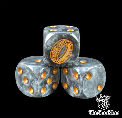 Close up of a black semi clear 16mm resin D6 die engraved with a gold ring and gold pips