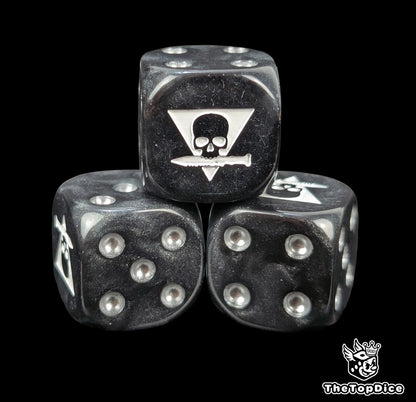 Close up of a black 16mm resin D6 die engraved with a triangle skull biting a white knife