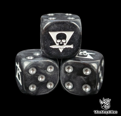 Close up of a black 16mm resin D6 die engraved with a triangle skull biting a white knife
