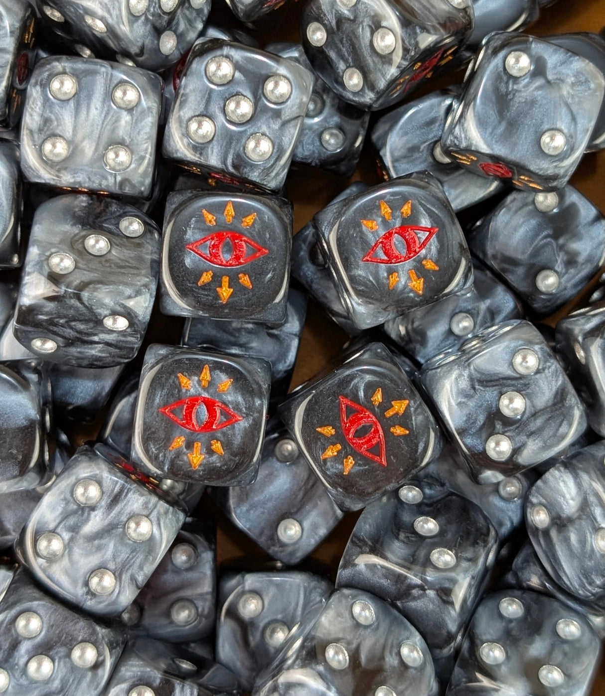 Pile of black traitor eye 16mm D6 dice for a sci-fi chaos army