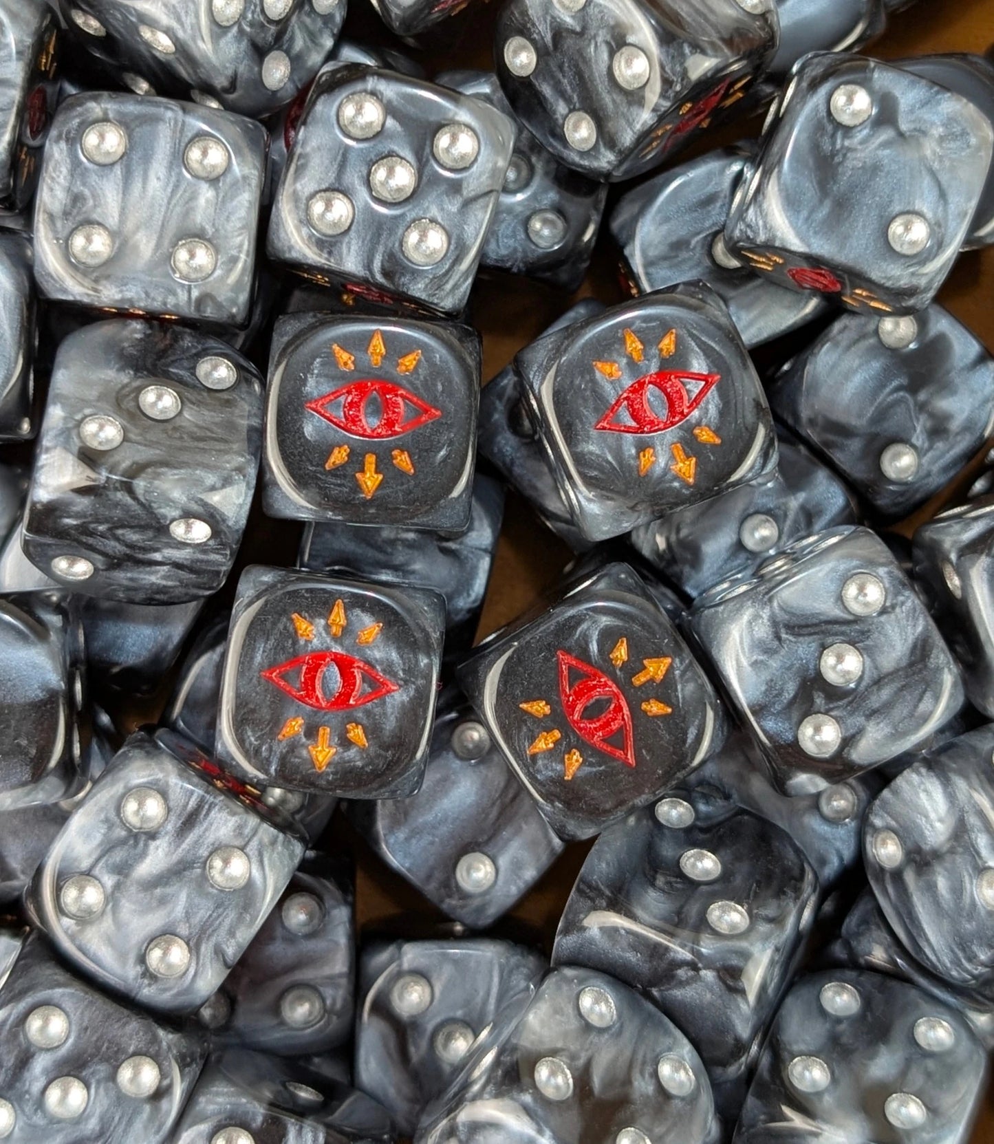 Pile of black traitor eye 16mm D6 dice for a sci-fi chaos army