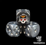 Close up of a black 16mm resin D6 die engraved with a white masked skull and silver pips
