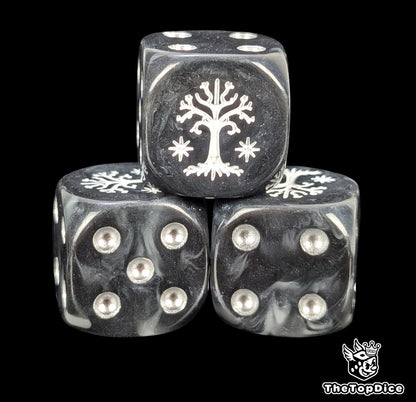 Close up of a black and grey 16mm resin D6 die engraved with a white tree and silver pips