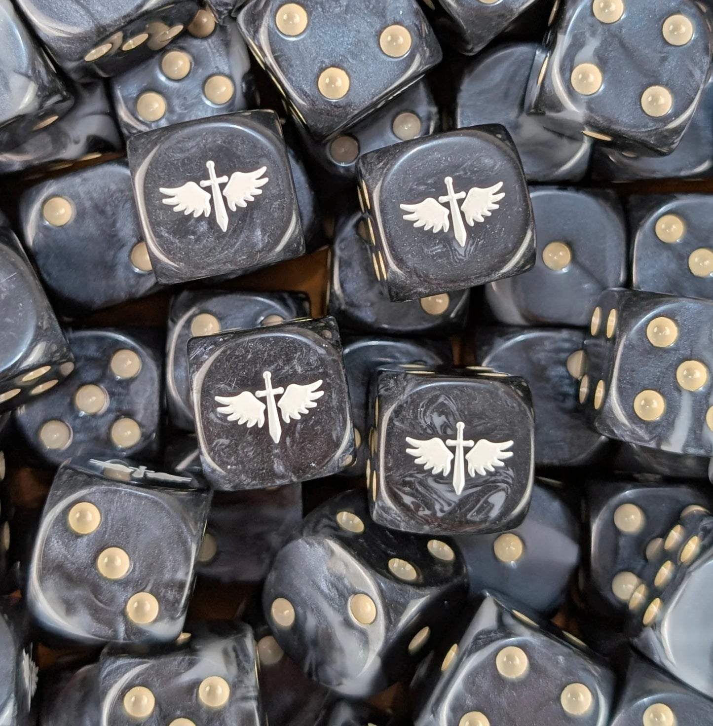 Pile of black and grey winged sword 16mm D6 dice for a sci-fi fast army