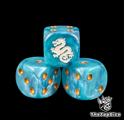 Close up of a blue 16mm resin D6 die engraved with a white eastern dragon and gold pips
