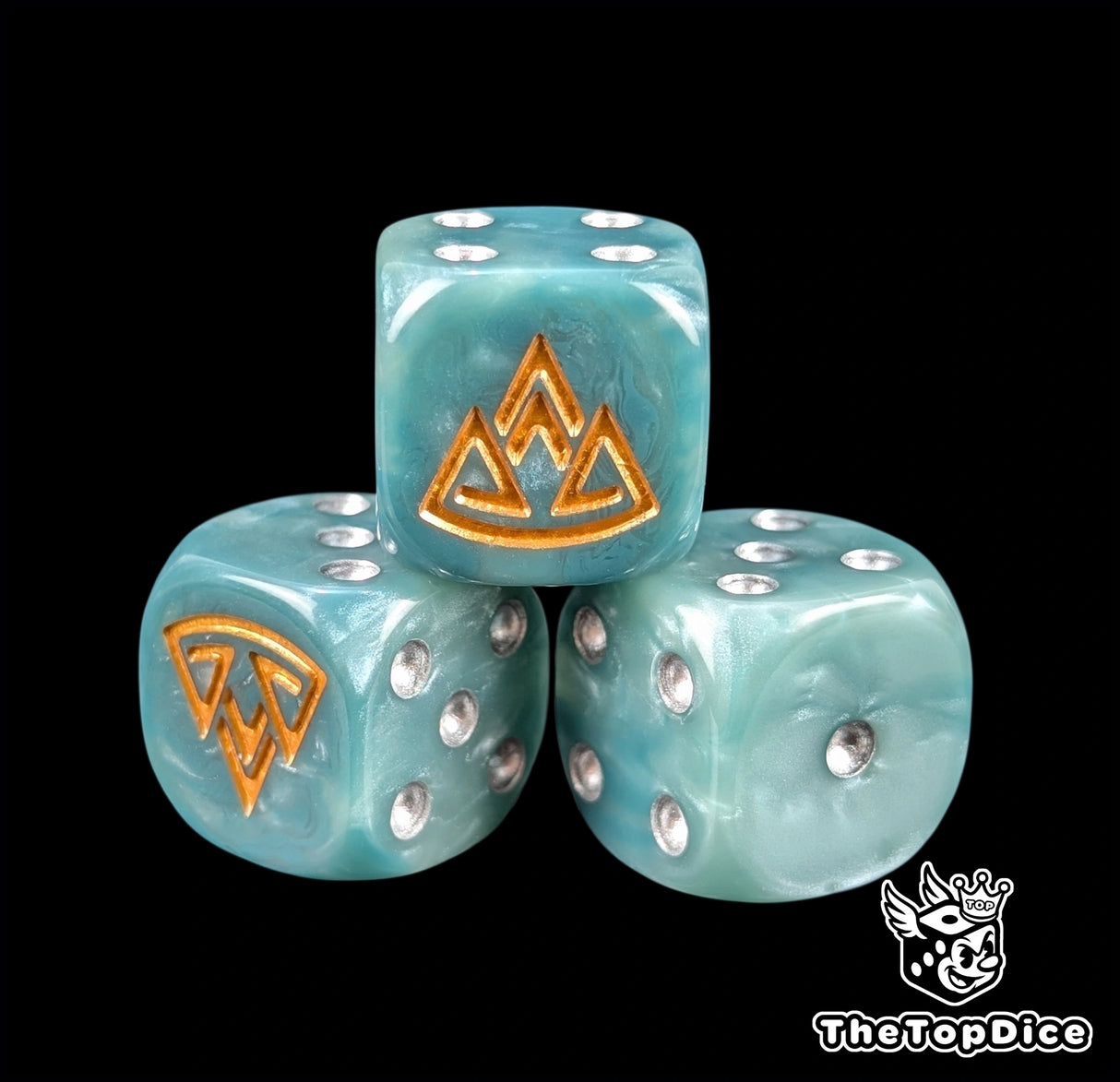 Close up of a blue 16mm resin D6 die engraved with a gold mountain emblem and silver pips