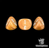 The white filling on three amber 16mm three sided dice, photographed close