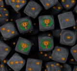 Pile of matte black first place trophy dice with gold pips and gold number one cups in a green laurel