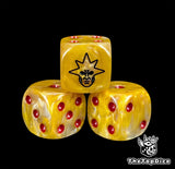 Close up of a gold 16mm resin D6 die engraved with a black winged angel mask and red pips