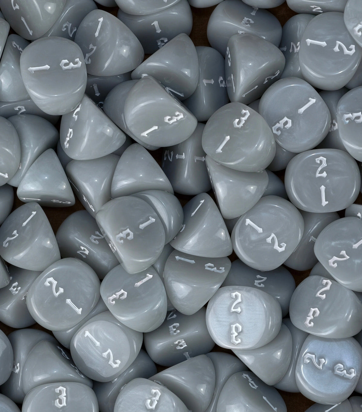 Neutral grey three sided dice loaded into a tray as objective markers