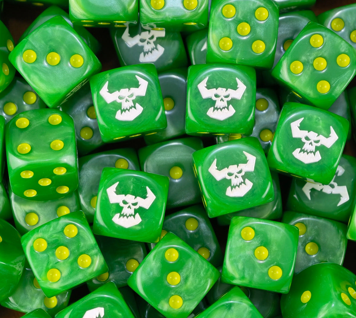 A pile of green Ork D6 with yellow pips and white horned skulls