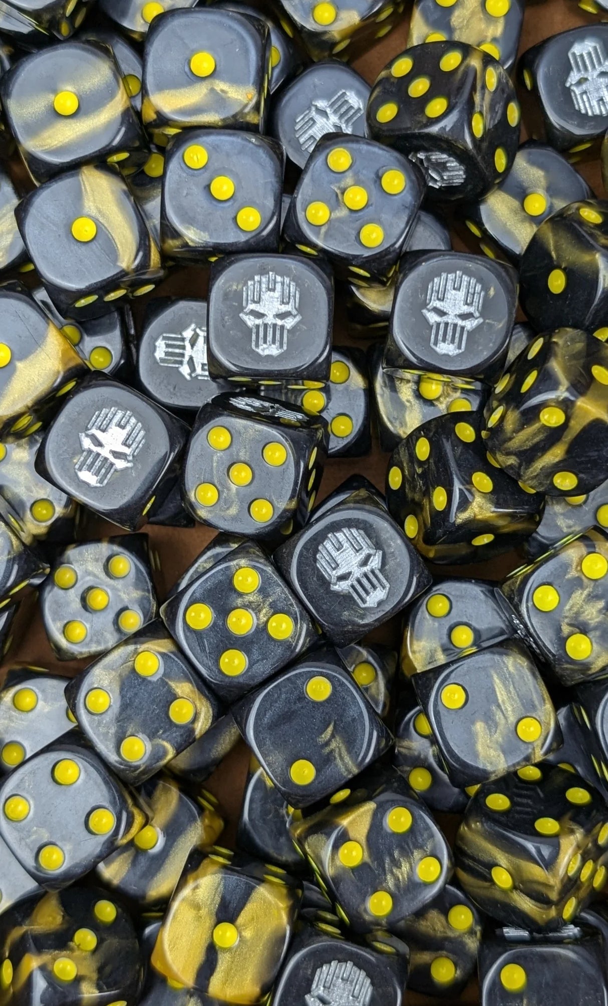 Pile of gold and black iron 16mm D6 dice for a sci-fi siege legion