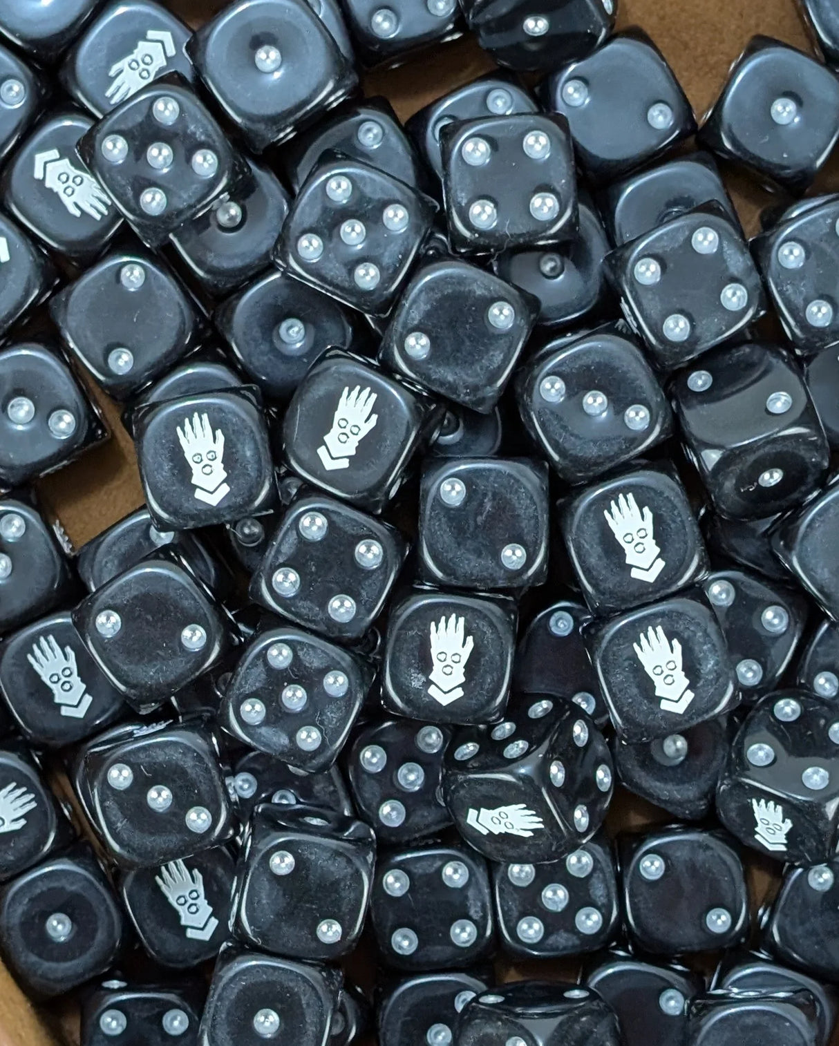 Pile of black iron fist 16mm D6 dice for a sci-fi cybernetic army