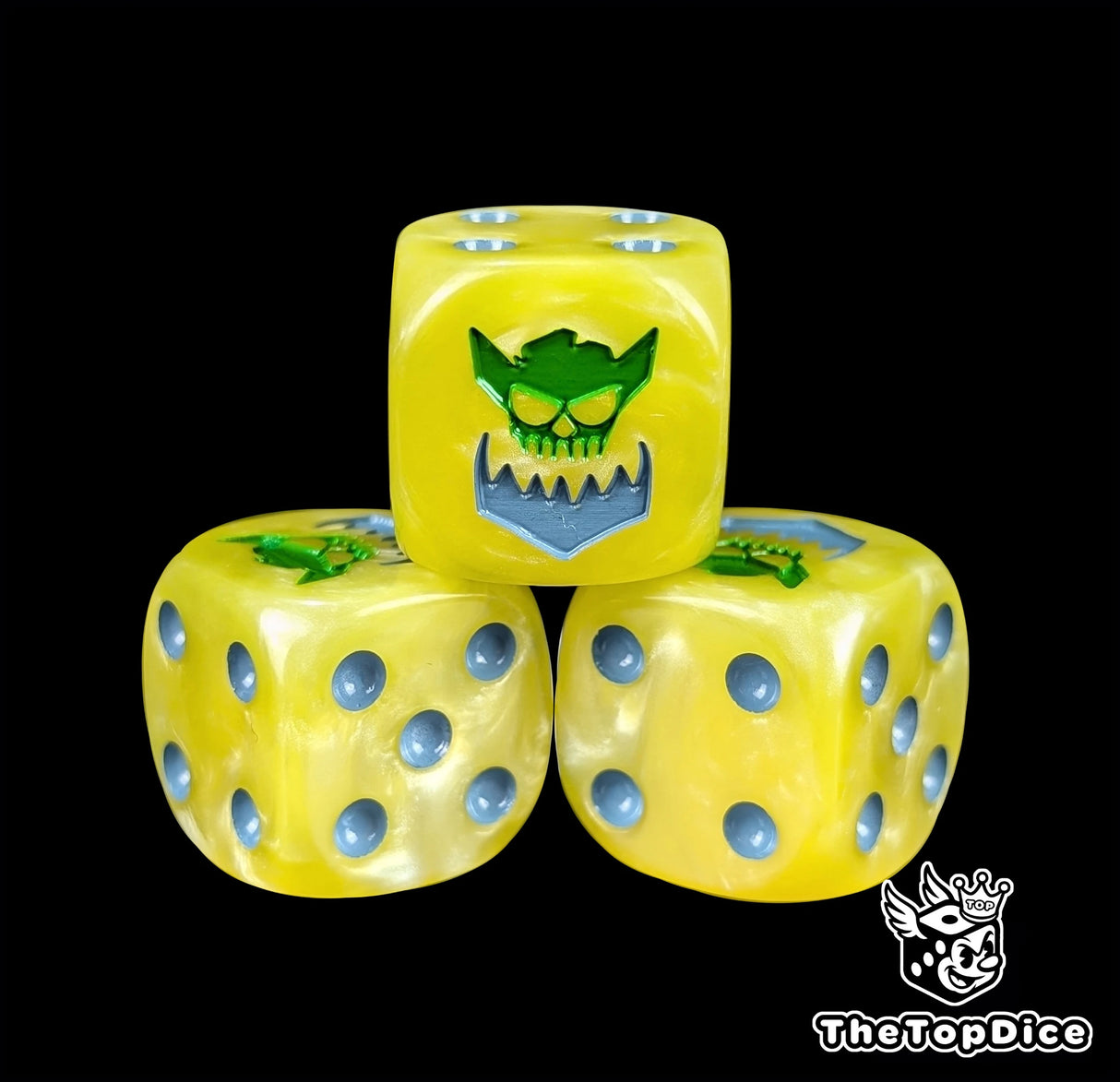 Close-up of a yellow D6 die with a green orc face and metal jaw