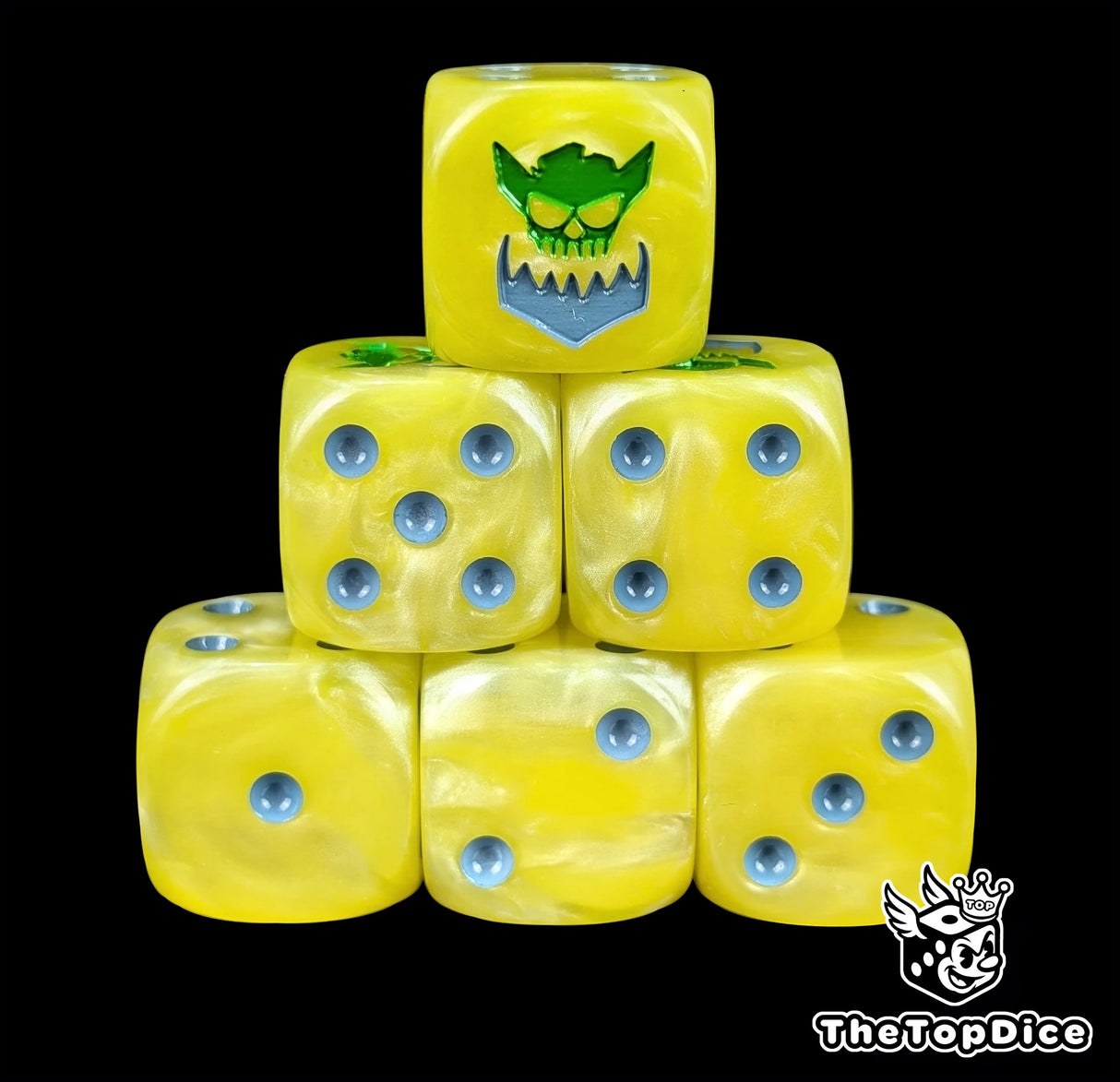 Yellow resin D6 dice with a green orc and metal jaw emblem and silver pips
