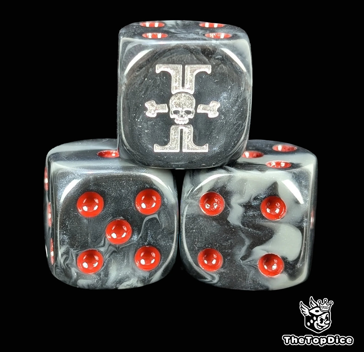 Close up of a black 16mm resin D6 die engraved with a skull set inside a silver sigil and red pips