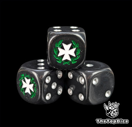 Close up of a black 16mm resin D6 die engraved with a white cross wreathed in a green laurel