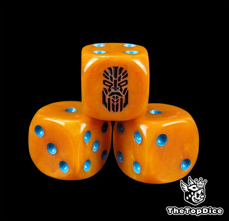 Close up of an orange 16mm resin D6 die engraved with a black kin rune and blue pips