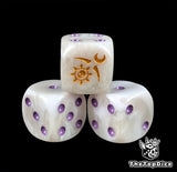 Close up of a pale white 16mm resin D6 die engraved with a gold crescent sigil and purple pips