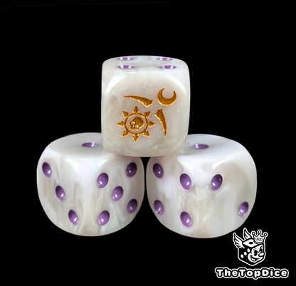 Close up of a pale white 16mm resin D6 die engraved with a gold crescent sigil and purple pips