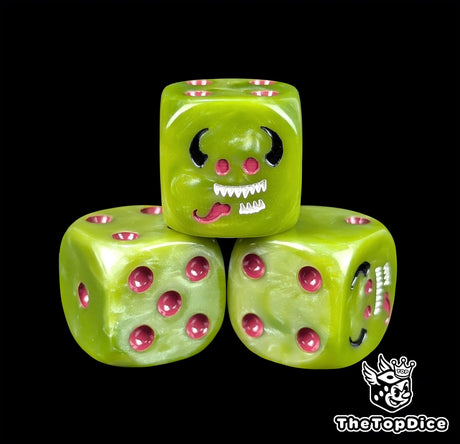 Close up of a green 16mm resin D6 die engraved with a grinning imp face and purple pips