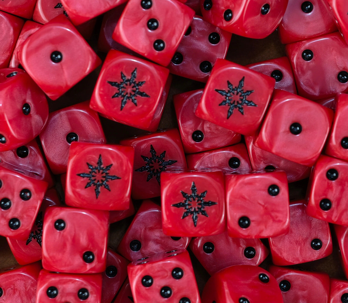 Pile of red chaos dice with black pips and black eight pointed stars